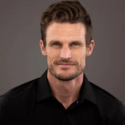 Professional headshot of man in black shirt