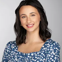 Professional headshot of woman with dark hair in blue floral top