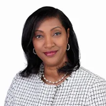 Professional headshot of woman in black and white checkered jacket