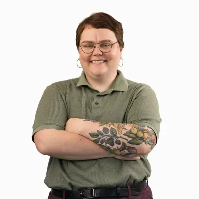 Professional headshot of person with short brown hair in green polo