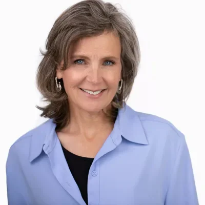 Professional headshot of woman with shoulder-length brown hair in light blue shirt