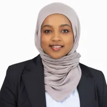 Professional headshot of woman in hijab and black blazer