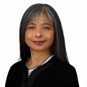 Professional headshot of a woman with long black and silver hair wearing a black top with white trim